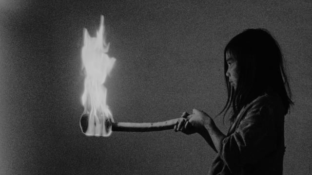 A girl holds a torch on fire