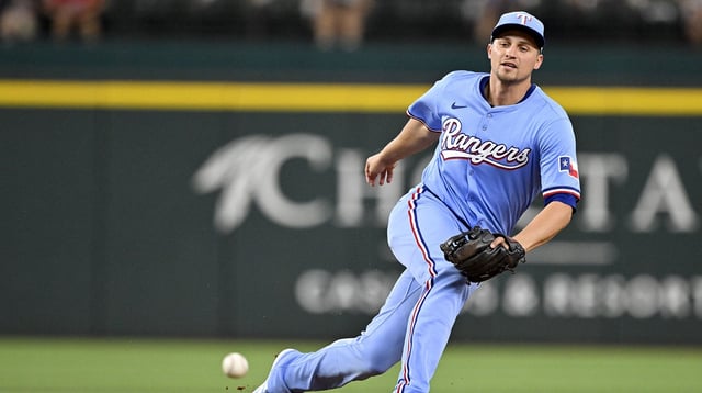 Aug 24, 2025; Arlington, Texas, USA; Texas Rangers shortstop Corey Seager (5) cannot field a ball hit by Cleveland Guardians second baseman Brayan Rocchio (not pictured) during the second inning at Globe Life Field. Mandatory Credit: Jerome Miron-Imagn Images