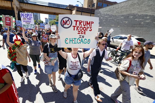 Protesters hold signs as they march during a "Workers over billionaires" rally on Labor Day in Chicago, Illinois, on September 1, 2025.