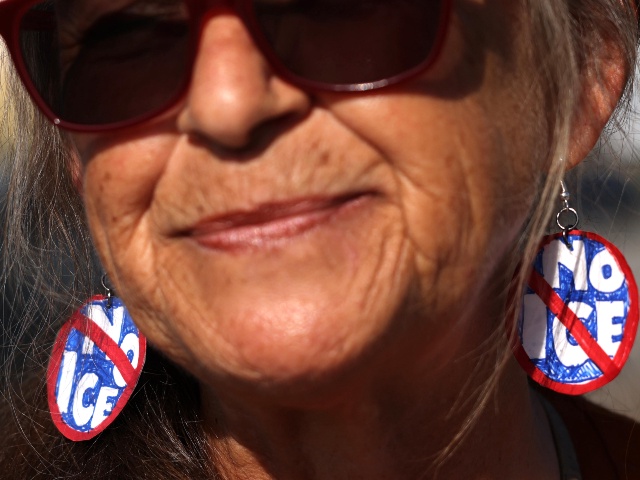 Anit-ICE protester Mary Rose O'Leary wears the appropriate earrings while joining other activists who march outside the Home Depot in Pasadena in hopes that the store will protect day laborers at the facility on August 6, 2025. (Genaro Molina/Los Angeles Times via Getty)
