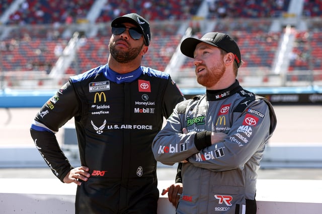Bubba Wallace, driver of the #23 U.S. Air Force Toyota, (L) and Tyler Reddick, driver of the #45 Mobil 1 Toyota, talk on the grid during qualifying for the NASCAR Cup Series Shriners Children's 500 at Phoenix Raceway on March 09, 2024 in Avondale, Arizona.