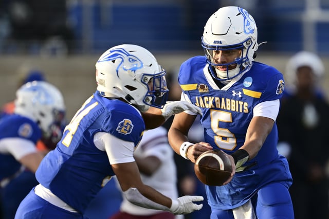Jon Bell #5 of the South Dakota State Jackrabbits hands off the ball during the fourth quarter of a game against the Montana Grizzlies at Dana J Dykhouse Stadium on December 7, 2024 in Brookings, South Dakota.