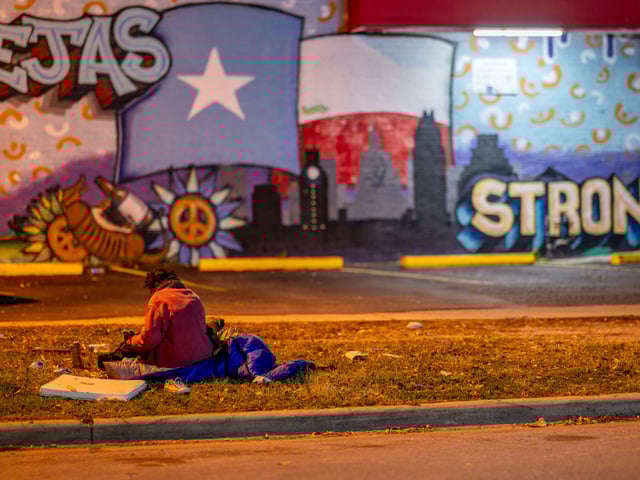 An unhoused person sits on the grass near a gas station on December 18, 2023 in Austin, Texas. The federal government has reported an increase in homelessness nationwide across all household types. Homelessness has increased 12 percent from 2022, roughly equating to more than 70,000 people. People identifying as African Americans, or Black, and Indigenous groups continue to be among those experiencing homelessness in the greatest numbers, with people identifying as Asian Americans, or Asians having the greatest percentage increase. Among the list, those identifying as Hispanics or Latin(a)(o)(x) experienced the largest numerical increase, equating to over 39,000 people from the year prior. Speaking on the increase, the head of the United States Interagency Council on Homelessness said "The most significant causes are the shortage of affordable homes and the high cost of housing." (Brandon Bell/Getty)