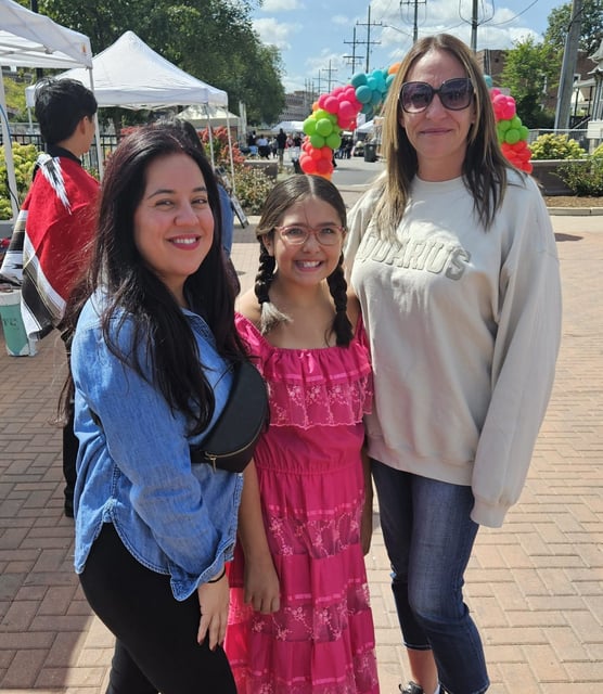 From left, Alex Gonzalez of Montgomery and her daughter Gianna Ferrer, 10, and friend Nicole Barnes, also of Montgomery, enjoy a moment at the annual Fiestas Patrias celebration in Wilder Park in Aurora on Saturday. The celebration concludes on Sunday with a parade in downtown Aurora. (David Sharos/For The Beacon-News)