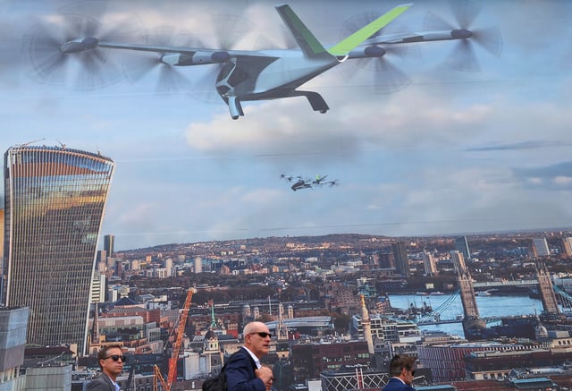 Attendees walk past an advert for a Supernal concept eVTOL (electric take off and landing vehicle) at the Farnborough International Airshow, in Farnborough, Britain, July 22, 2024. REUTERS/Toby Melville/File Photo