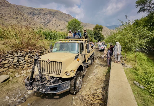 Afghan men ride in a Taliban military truck towards Lulam village to help the victims following a deadly magnitude 6 earthquake that struck Afghanistan on Sunday, in Nurgal district, Kunar province, Afghanistan, September 3, 2025. REUTERS/Sayed Hassib