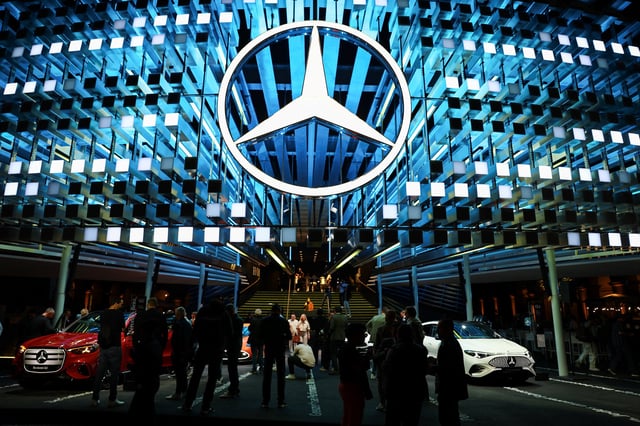 People stand near the latest Mercedes-Benz electric GLC model during a world premiere, ahead of the IAA auto show, in Munich, Germany, September 7, 2025.  REUTERS/Kai Pfaffenbach