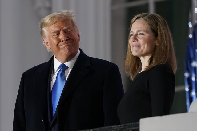 President Donald Trump and Amy Coney Barrett stand on the Blue Room Balcony after Supreme Court Justice Clarence Thomas administered the Constitutional Oath to her on the South Lawn of the White House White House in Washington, Oct. 26, 2020.