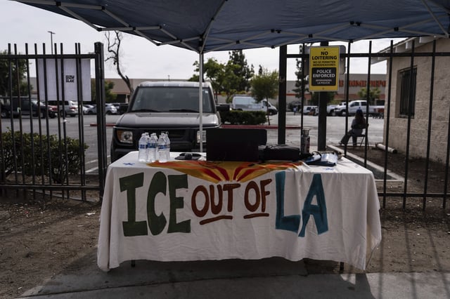 A table covered with a cloth reading "ICE Out of LA" sits under a canopy next to the job center for day laborers outside a Home Depot in the Van Nuys section of Los Angeles, Aug. 28, 2025. (AP Photo/Jae C. Hong)