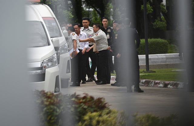 Former Thai Prime Minister Thaksin Shinawatra is escorted by corrections officers after the supreme court ruled to return Thaksin to prison for one year, in the case of his unlawful six-month hospital stay before he was granted parole, in Bangkok, Thailand, September 9, 2025. REUTERS/Panumas Sanguanwong
