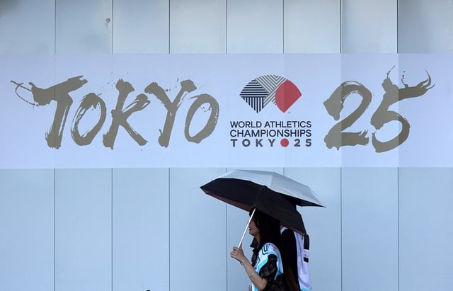 People walk in front of an advertising banner for the upcoming World Athletics Championships Tokyo 25, near the National Stadium in Tokyo, Japan, September 6, 2025.  REUTERS/Fabrizio Bensch