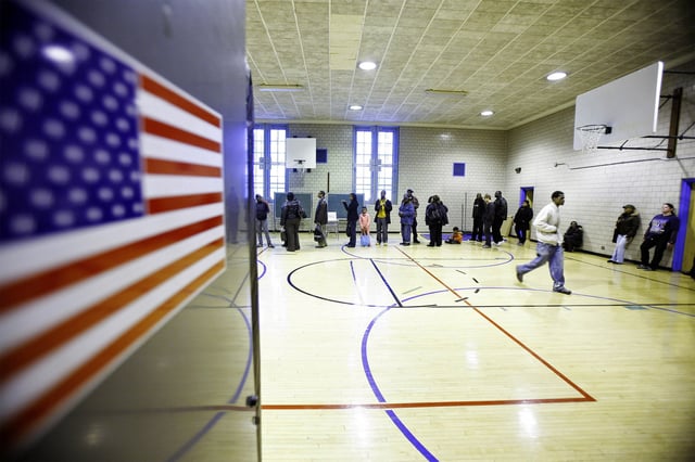 Voters line up to cast their ballots in a school gymnasium in the Harlem neighborhood of New York, November 4, 2008. REUTERS/Lucas Jackson/File Photo