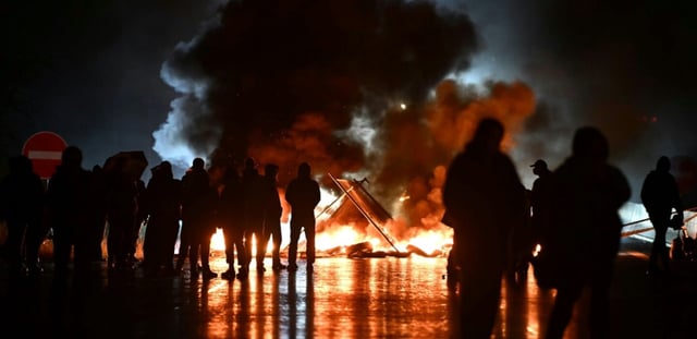Des manifestants du mouvement "Bloquons tout" près d'objets en feu sur le viaduc de Calix, le 10 septembre 2025