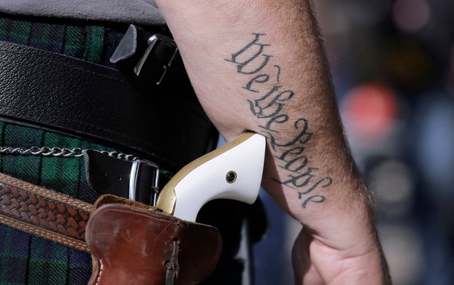 A supporter of open carry gun laws, wears a pistol as he prepares for a rally in support of open carry gun laws at the Capitol in Austin, Texas in 2015. A measure to allow open carrying of firearms in Florida was introduced this week in the state House, then quickly withdrawn. Plans to drop the state permit requirement for people to carry concealed weapons are moving forward.