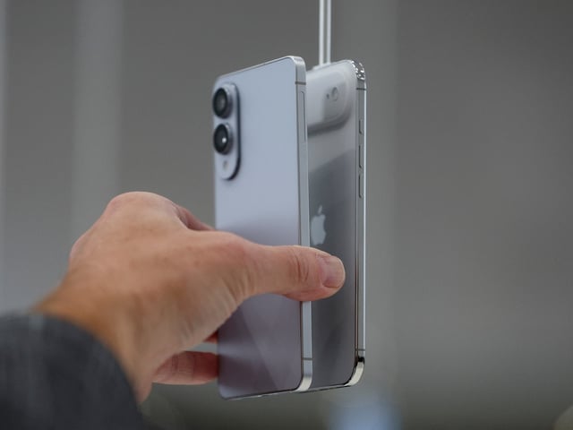 A person holds a Samsung Galaxy S25 Edge phone in front of an iPhone Air during Apple's event at the Steve Jobs Theater, in Cupertino, California, U.S. September 9, 2025. REUTERS/Manuel Orbegozo