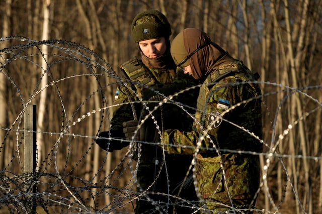 Estonian army reservists build a temporary razor wire fence on a border with Russia during a snap military exercise Okas 2021 near Meremae, Estonia November 20, 2021. REUTERS/Ints Kalnins/File Photo