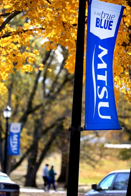 An MTSU banner stands out against the changing leaves as people cross the Middle Tennessee State University campus in the background on Friday afternoon Nov. 10, 2023, in Murfreesboro, Tenn.