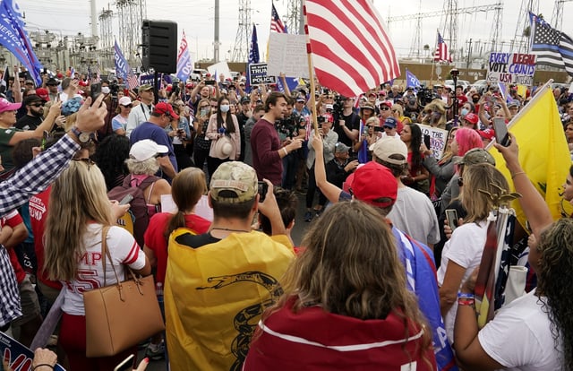 FILE - Charlie Kirk, center, conservative activist and founder of Turning Point USA, speaks to supporters of President Donald Trump at a rally, Nov. 6, 2020, in Phoenix. (AP Photo/Ross D. Franklin, File)