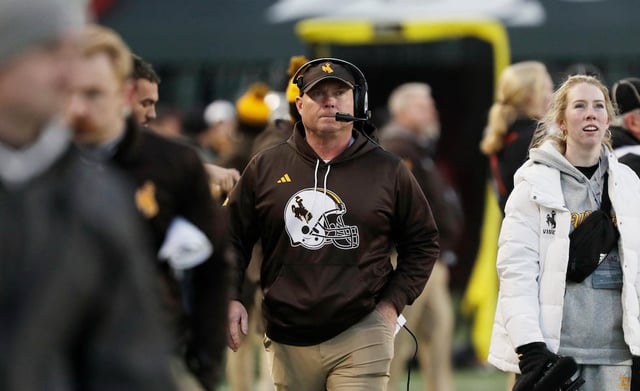 Wyoming head coach Jay Sawvel, center, walks on the sideline during the first half of a game against Washington State, Saturday, Nov. 30, 2024, in Pullman, Wash.