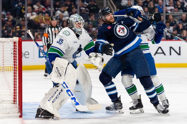 Adam Lowry #17 of the Winnipeg Jets battles in front of goaltender Thatcher Demko #35 of the Vancouver Canucks in the second period against the Vancouver Canucks at Canada Life Centre on March 30, 2025 in Winnipeg. 
