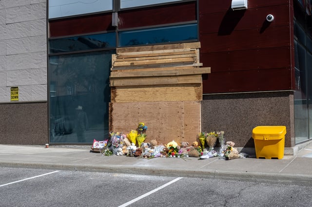 Members of the community leave flowers and toys in front of a damaged window the day after an SUV crashed into a daycare in Richmond Hill, Ont., on Thursday, Sept. 11, 2025. 