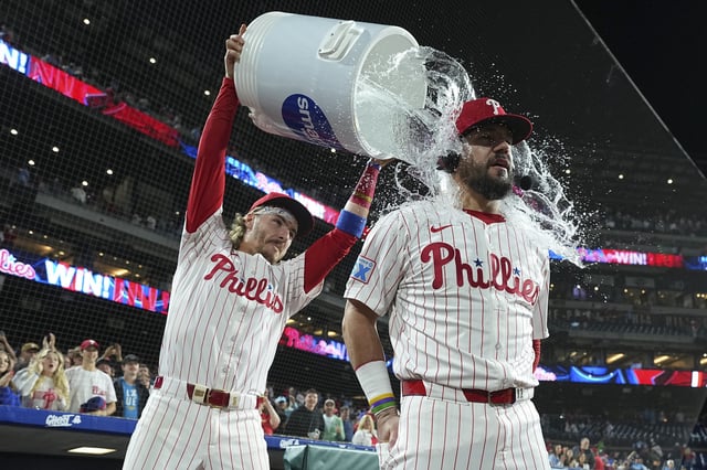PHILADELPHIA, PENNSYLVANIA - SEPTEMBER 9: Bryson Stott #5 of the Philadelphia Phillies pours water on Kyle Schwarber #12 after the game against the New York Mets at Citizens Bank Park on September 9, 2025 in Philadelphia, Pennsylvania. The Phillies defeated the Mets 9-3. (Photo by Mitchell Leff/Getty Images)