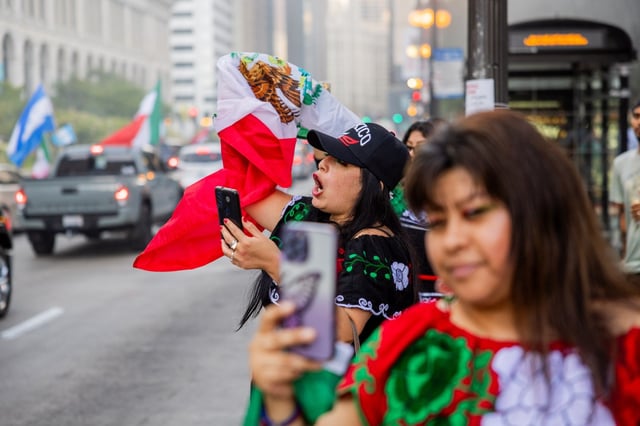 An individual cheers on Michigan Avenue in celebration of Mexican Independence Day in Chicago on Sept. 15, 2024. (Tess Crowley/Chicago Tribune)