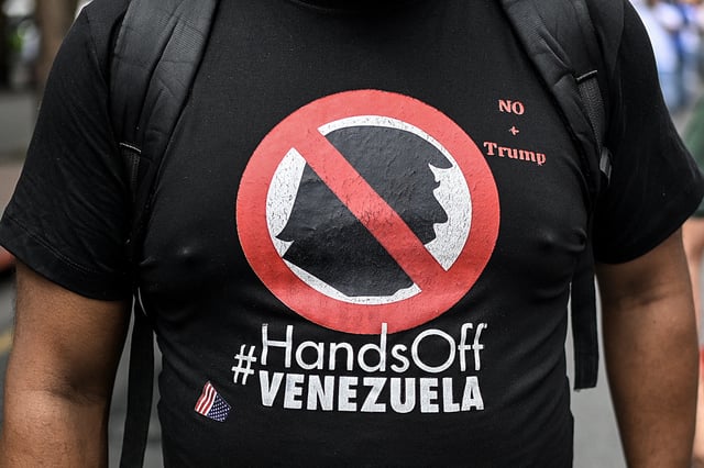 A t-shirt depicting US President Donald Trump that reads 'Hands off Venezuela' is seen while supporters of Venezuela's President Nicolas Maduro take part in a protest against the reward imposed by the US President, in Caracas on August 11, 2025.