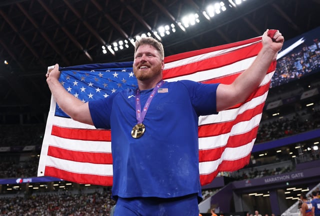 World Athletics Championships Tokyo 2025 - Men's Shot Put Final - Japan National Stadium, Tokyo, Japan - September 13, 2025 Ryan Crouser of the U.S. celebrates with a U.S. flag after winning gold REUTERS/Edgar Su