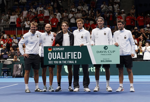 Tennis - Davis Cup - Qualifiers - Second Round - Japan v Germany - Ariake Coliseum, Tokyo, Japan - September 13, 2025 Germany's Justin Engel celebrates with his team mates by holding a qualified banner after winning his exhibition match against Japan's Rei Sakamoto REUTERS/Manami Yamada