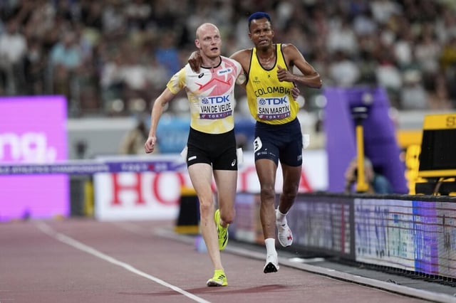 Colombia's Carlos San Martin and Belgium's Tim Van De Velde help each other to the nine during a men's 3,000 meters steeplechase heat at the World Athletics Championships in Tokyo, Saturday, Sept. 13, 2025. (AP Photo/Petr David Josek)