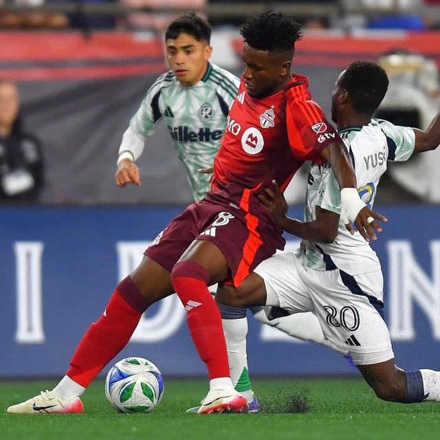Toronto FC midfielder Jose Cifuentes, front left, and New England Revolution midfielder Alhassan Yusuf, right, pursue the ball in the first half of an MLS soccer match, Saturday, Sept. 13, 2025, in Foxborough, Mass. (AP Photo/Steven Senne)