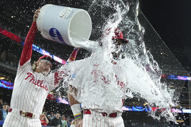 PHILADELPHIA, PENNSYLVANIA - SEPTEMBER 9: Bryson Stott #5 of the Philadelphia Phillies pours water on Kyle Schwarber #12 after the game against the New York Mets at Citizens Bank Park on September 9, 2025 in Philadelphia, Pennsylvania. The Phillies defeated the Mets 9-3. (Photo by Mitchell Leff/Getty Images)