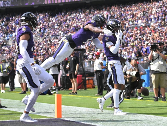 Ravens’ Chidobe Awuzie, left, jumps on Nate Wiggins to celebrate Wiggins interception in the third quarter at M&T Bank Stadium. (Kenneth K. Lam/Staff)