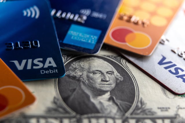 In this photo illustration the Visa, Mastercard and American Express logo on various credit cards and debit cards are seen beside US one dollar bills on February 4, 2025 in Somerset, England.