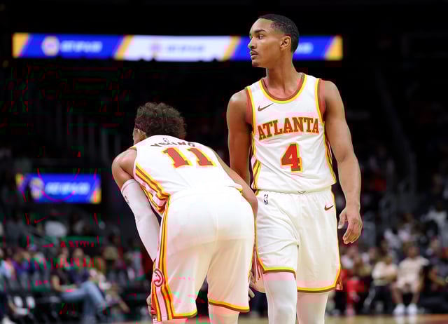 Kobe Bufkin #4 and Trae Young #11 of the Atlanta Hawks wait for play against the Cleveland Cavaliers during the second quarter at State Farm Arena on October 10, 2023 in Atlanta, Georgia. NOTE TO USER: User expressly acknowledges and agrees that, by downloading and/or using this photograph, user is consenting to the terms and conditions of the Getty Images License Agreement.
