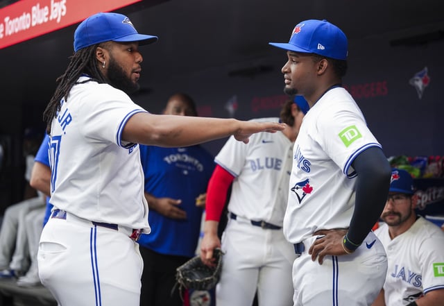 TORONTO, ON - JUNE 18: Vladimir Guerrero Jr. #27 and Orelvis Martinez #13 of Toronto Blue Jays talk before play against the Boston Red Sox in their MLB game at the Rogers Centre on June 18, 2024 in Toronto, Ontario, Canada.