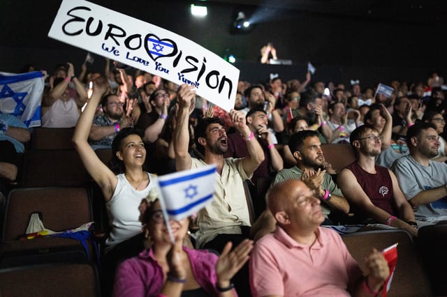 People cheer as they watch the 2025 Eurovision Song Contest finals being screened at a community center in Tel Aviv, Israel, on May 17, 2025.