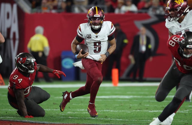 Jan 12, 2025; Tampa, Florida, USA; Washington Commanders quarterback Jayden Daniels (5) scrambles against Tampa Bay Buccaneers defensive tackle Calijah Kancey (94) during the second quarter of a NFC wild card playoff at Raymond James Stadium. Mandatory Credit: Kim Klement Neitzel-Imagn Images/File Photo