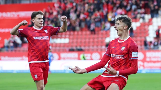 Zwei Spieler in roten Trikots jubeln