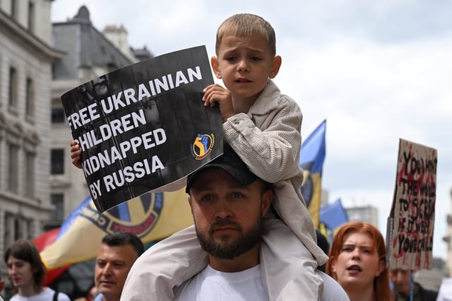 A boy holds up a sign during the March for the Children of Ukraine protest in London, Britain, June 1, 2025. REUTERS/Jaimi Joy