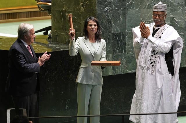 Secretary-General António Guterres, left, and former president of the General Assembly Philemon Yang, right, look on, as Annalena Baerbock, center, holds up a gavel after being sworn in as the president of the 80th session of the United Nations General Assembly at United Nations headquarters, Tuesday, Sept. 9, 2025. (AP Photo/Seth Wenig)