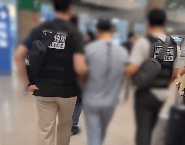 This photo, provided by the Gyeonggi Nambu Provincial Police on Sept. 17, 2025, shows a Chinese national being apprehended by police for allegedly making unauthorized mobile payments by hacking users of KT Corp. (PHOTO NOT FOR SALE) (Yonhap)
