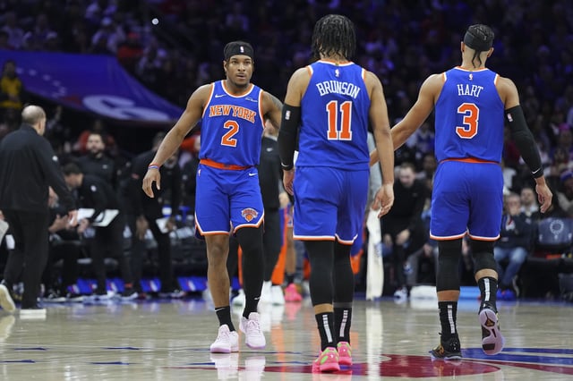 Miles McBride #2, Jalen Brunson #11, and Josh Hart #3 of the New York Knicks react against the Philadelphia 76ers at the Wells Fargo Center on January 15, 2025 in Philadelphia, Pennsylvania. The Knicks defeated the 76ers 125-119 in overtime.