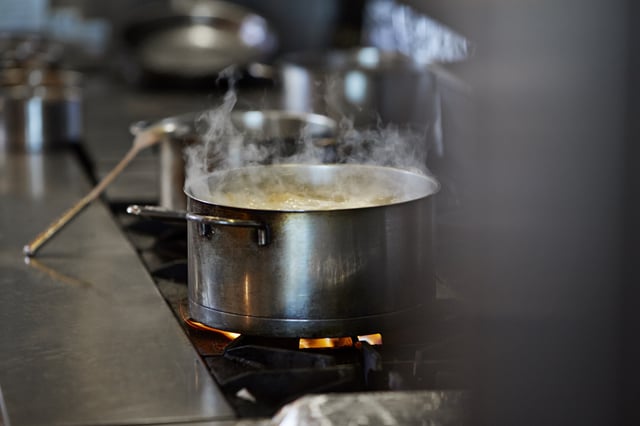 Font cooking on stow in kitchen at restaurant
