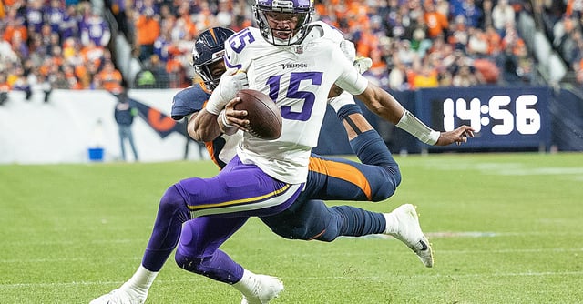 Vikings quarterback Joshua Dobbs (15) breaks the grasps of Broncos linebacker Jonathon Cooper (0) for a short pass to Vikings tight end Josh Oliver (84) for a touchdown in the second quarter at Empower Field at Mile High in Denver, CO., on Sunday, Nov. 19, 2023. ] Elizabeth Flores • liz.flores@startribune.com