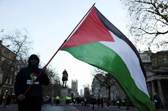 A person holds a Palestinian flag during a protest in solidarity with Palestinians in Gaza, amid the ongoing conflict between Israel and the Palestinian Islamist group Hamas, in London, Britain, December 9, 2023. REUTERS/Hollie Adams/File Photo
