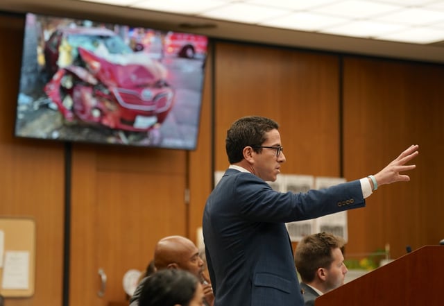 Plaintiff’s attorney Robert Glassman shows jurors a photo during opening statements – of his client’s car, wrecked after it was struck by an LAPD cruiser in Encino in 2024.
