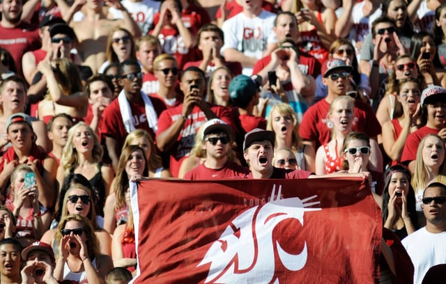 Ben Allen, a junior at Washington State, cheers on the Cougars as they take on the Southern Utah Thunderbirds before the start of an NCAA college football game, Saturday, Sept. 14, 2013, in Pullman, Wash. (AP Photo/Rajah Bose)