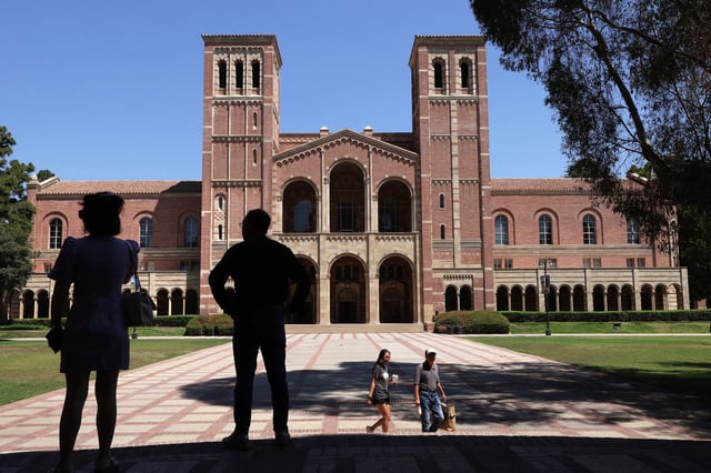 Two people look out at Royce Hall on the UCLA campus in the Westwood neighborhood of Los Angeles on Aug. 7, 2025.